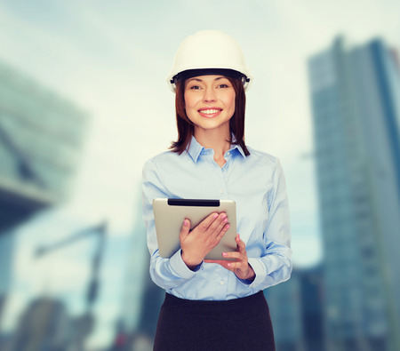 building, developing, consrtuction and architecture concept - friendly young smiling businesswoman in white helmetの写真素材