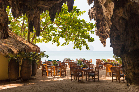 leisure, travel and tourism concept - view to open-air restaurant on beach resort from caveの写真素材