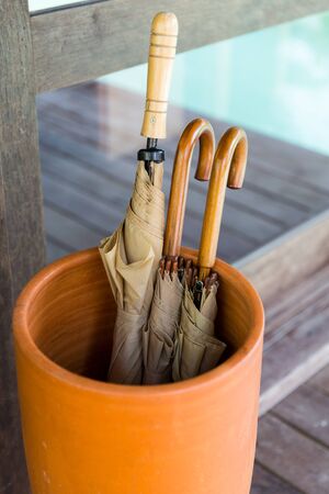 rainy weather, accessories and storing - vase with umbrellas on terrace at hotel or homeの写真素材