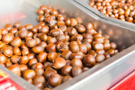 cooking, asian kitchen, sale and food concept - chestnuts at street marketの写真素材