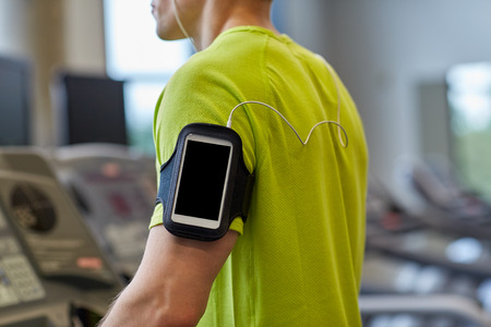 sport fitness lifestyle technology and people concept  close up of man with smartphone and earphones...