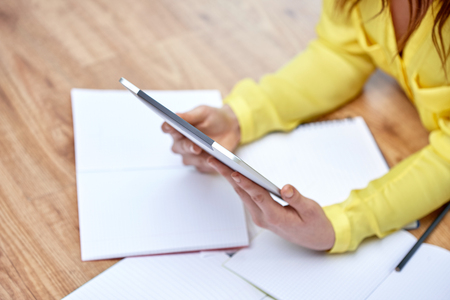 close up of female hands with tablet pc computer and notebooks lying on floorの写真素材