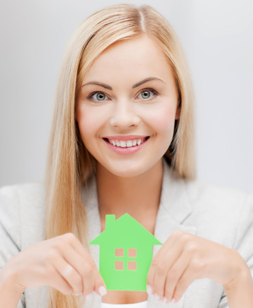 smiling busineswoman with green eco house symbolの写真素材