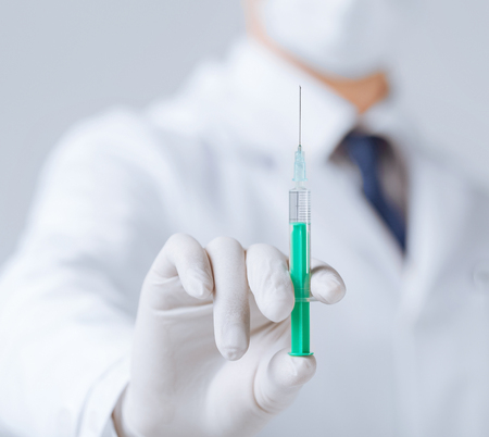close up of male doctor holding syringe with injectionの写真素材