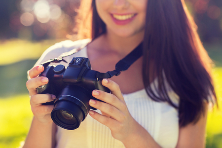 lifestyle, summer, vacation, technology and people concept - close up of young girl with photo camera outdoorsの写真素材