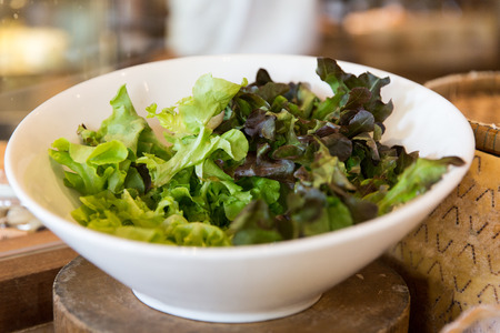 cooking, kitchen and food concept - bowl of green salad lettuce at asian restaurant