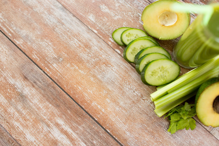 healthy eating, organic food, advertisement and diet concept - close up of fresh green juice glass and vegetables on blank tableの写真素材