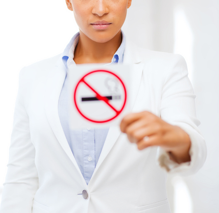 health and healthcare concept - picture of african woman with restriction no smoking signの写真素材