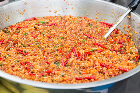 cooking, asian kitchen, sale and food concept - chilly wok or pilaf dish at street market