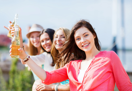 summer holidays and vacation - girls with drinks on the beachの写真素材