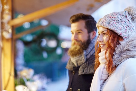 holidays, winter, christmas and people concept - happy couple in warm clothes outdoorsの写真素材