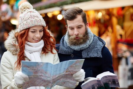holidays, winter, christmas, tourism and people concept - happy couple in warm clothes with map and...