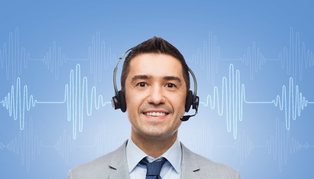 business, people, technology and service concept - smiling businessman in headset over sound wave or...