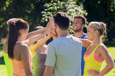 fitness, sport, friendship and healthy lifestyle concept - group of happy teenage friends or sportsmen making high five outdoors fitness, sport, friendship and healthy lifestyle concept - group of happy teenage friends or sportsmen making high five outdoors