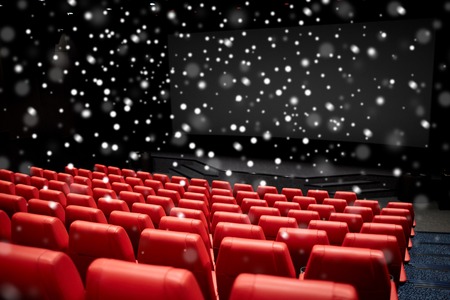 entertainment and leisure concept - movie theater or cinema empty auditorium with red seats over snowflakes