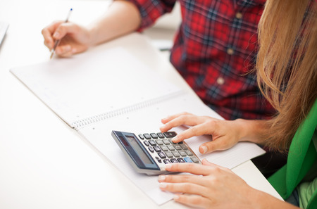 education, people, mathematics and high school concept - close up of students with notebook and...