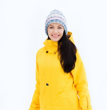winter, leisure, clothing and people concept - happy young woman in winter clothes outdoorsの写真素材