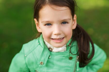 summer, childhood, happiness and people concept - happy beautiful little girl portrait outdoorsの写真素材