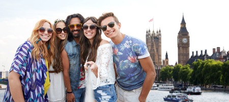 summer vacation, travel, tourism, technology and people concept - smiling young hippie friends...