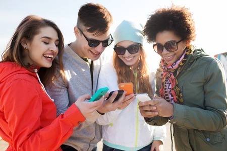 people, friendship, cloud computing and technology concept - group of smiling teenage friends with...
