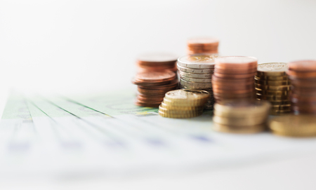 business, finance, investment, saving and cash concept - close up of euro paper money and coins on tableの写真素材