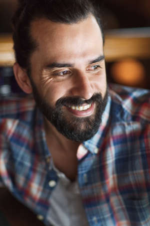 people and men concept - happy young man with beard and mustache in checkered shirtの写真素材