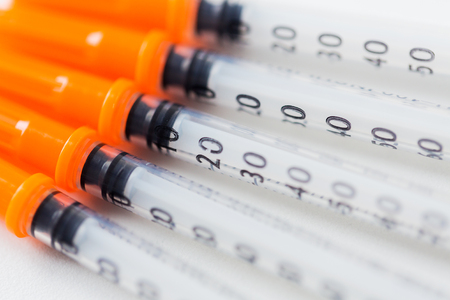 medicine, diabetes and health care concept - close up of insulin syringes on tableの写真素材