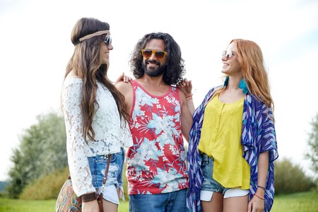 nature, summer, youth culture and people concept - smiling young hippie friends in sunglasses talking outdoorsの写真素材