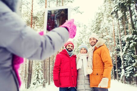 technology, season, friendship and people concept - group of smiling men and women taking picture...