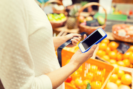 sale, shopping, consumerism and people concept - close up of young woman with food basket in marketの写真素材