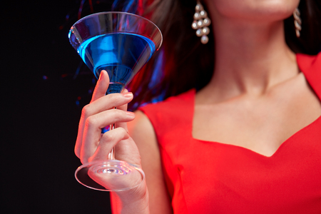 people, holidays, party, alcohol and leisure concept - close up of woman with cocktail at nightclubの写真素材