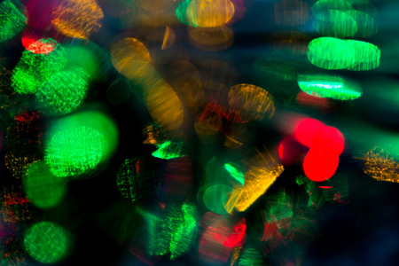 holidays, illumination and electricity concept - colorful bright night lights bokeh over dark backgroundの写真素材