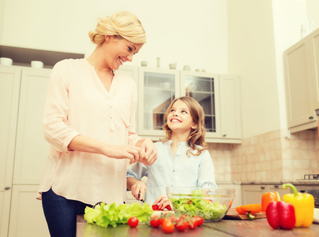 food, family, hapiness and people concept - happy family making dinner in kitchenの写真素材