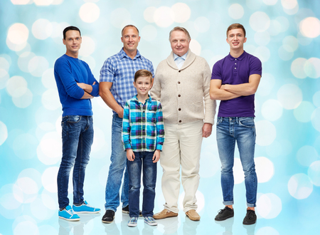 male, gender, generation and people concept - group of smiling men and boy over blue holidays lights...