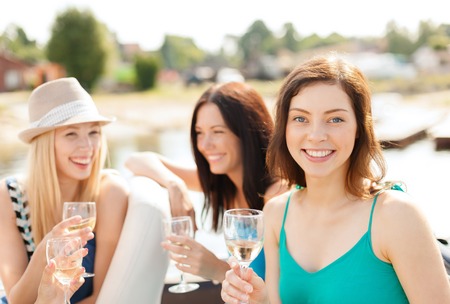 summer holidays, vacation and celebration concept - smiling girls with champagne glassesの写真素材