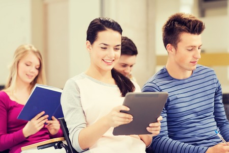 education, high school, teamwork and people concept - group of smiling students with tablet pc computers sitting in lecture hallの写真素材