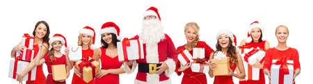 people, holidays, christmas and celebration concept - santa calaus and happy women with gift boxesの写真素材