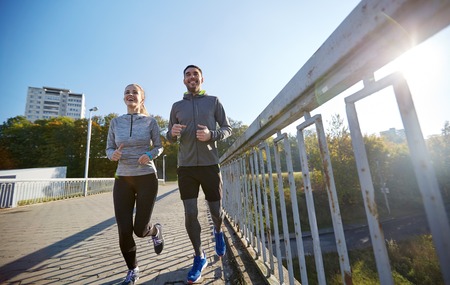 fitness, sport, people and lifestyle concept - happy couple running outdoors