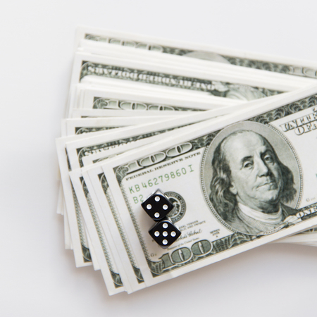 casino, gambling and fortune concept - close up of black dice and dollar cash money