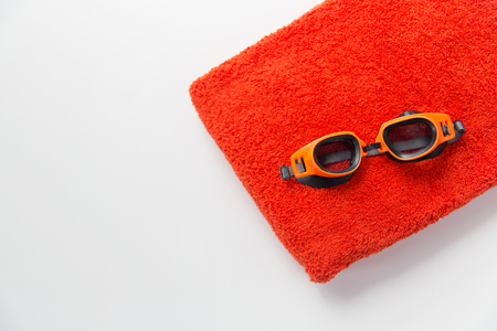 sport, fitness, water sports and objects concept - close up of swimming goggles and towelの写真素材
