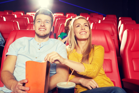 cinema, entertainment and people concept - happy friends watching movie in theaterの写真素材