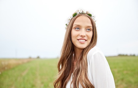 nature, summer, youth culture and people concept - smiling young hippie woman wearing flower wreath on cereal fieldの写真素材