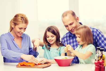 food, family, children, hapiness and people concept - happy family with two kids making dinner at homeの写真素材