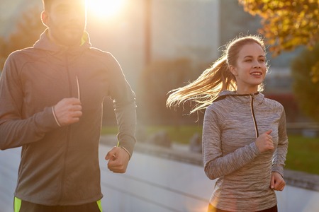 happy couple running outdoorsの写真素材