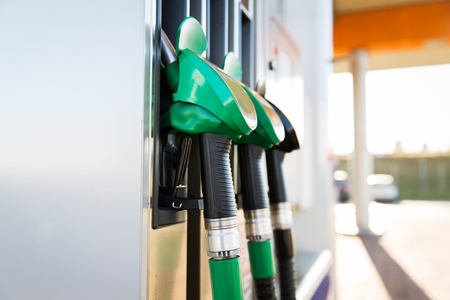 object, fuel, oil, tank and transport concept - close up of gasoline hose at gas stationの写真素材