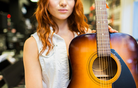 music, sale, people, musical instruments and entertainment concept - close up of female assistant or...