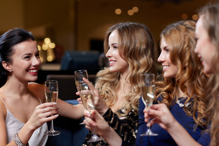 celebration, friends, bachelorette party and holidays concept - happy women with champagne glasses at night clubの写真素材