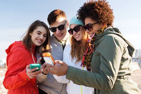 people, friendship, cloud computing and technology concept - group of smiling teenage friends with...