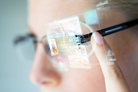 business, media, future technology, information and people concept - close up of woman in eyeglasses...