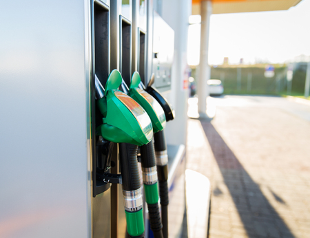 object, fuel, oil, tank and transport concept - close up of gasoline hose at gas stationの写真素材